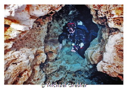 Cave diver passing through the keyhole rock formation in ... by Michael Grebler 